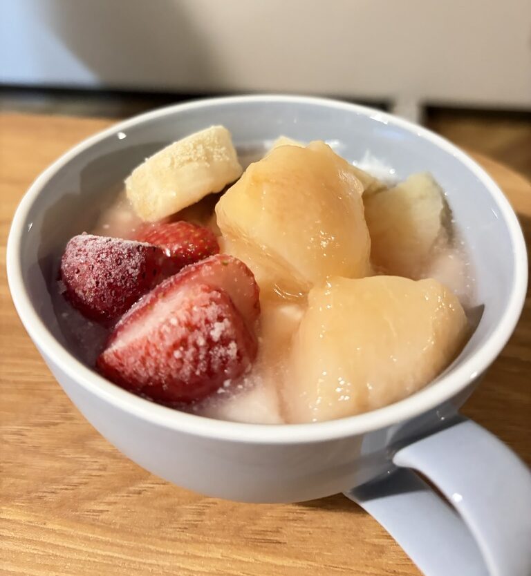 ヨーグルトに桃のカルダモンコンポートをのせ、冷凍のいちごとバナナを添えた朝食
